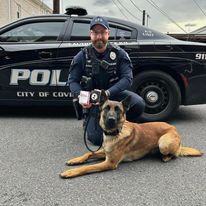 Jacob and Bear posing in front of their patrol car.